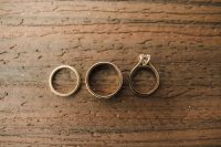 Three rings sit side by side on a wooden plank.