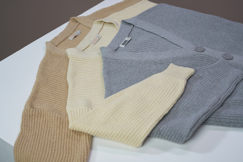 Three soft knit sweaters, one grey, one beige and one brown